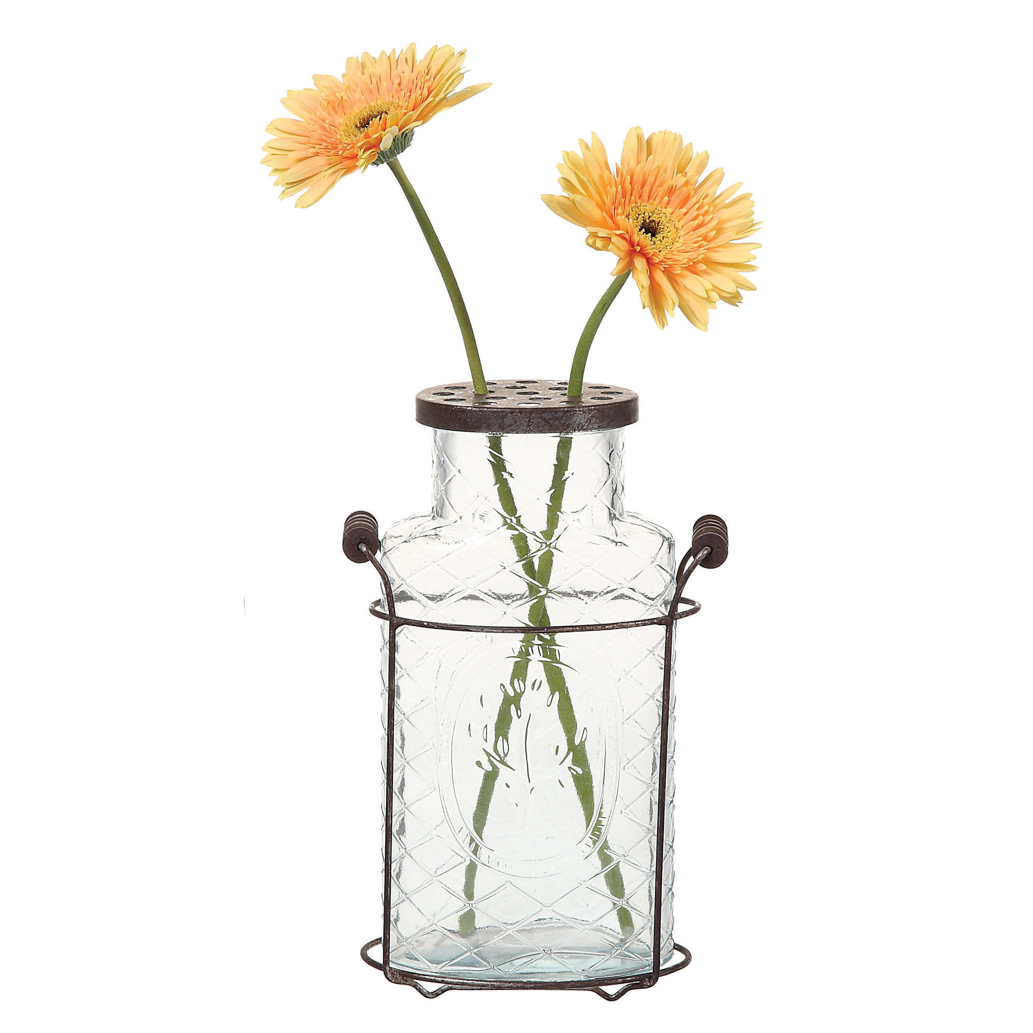 A clear glass vase with a metal stand and frog lid, containing two orange flowers.